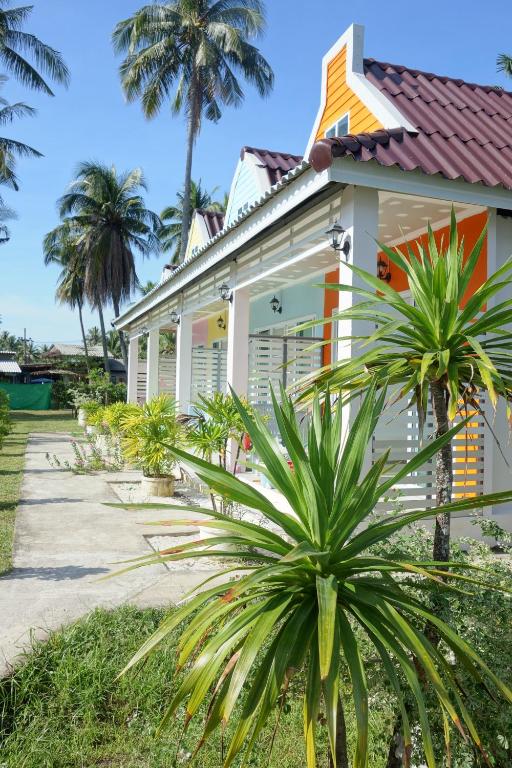 a house with palm trees in front of it at Mook Ing Lay in Ko Mook
