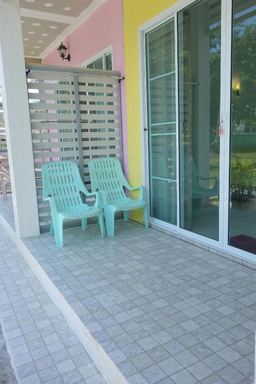 two benches sitting on the porch of a house at Mook Ing Lay in Ko Mook
