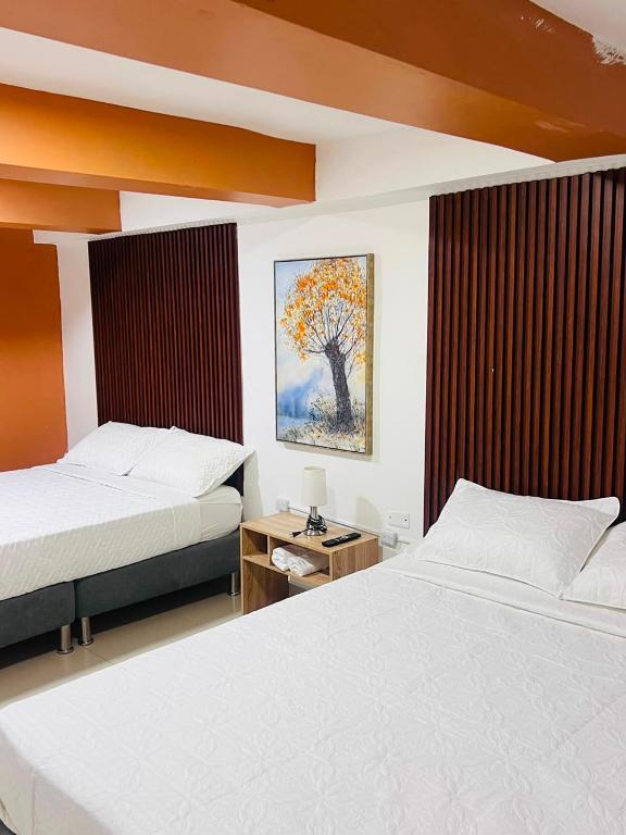 a bedroom with two beds and a painting on the wall at Mosaico Cartagena Hotel in Cartagena de Indias