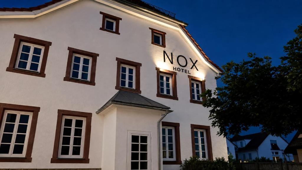 a white building with a nox sign on it at NOX HOTEL - Digital-Check-In & Virtual Reception - nahe Bretten & Karlsruhe in Wössingen