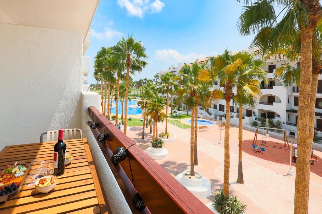 a balcony with a view of a pool and palm trees at Casa Avina Bliss in Los Alcázares