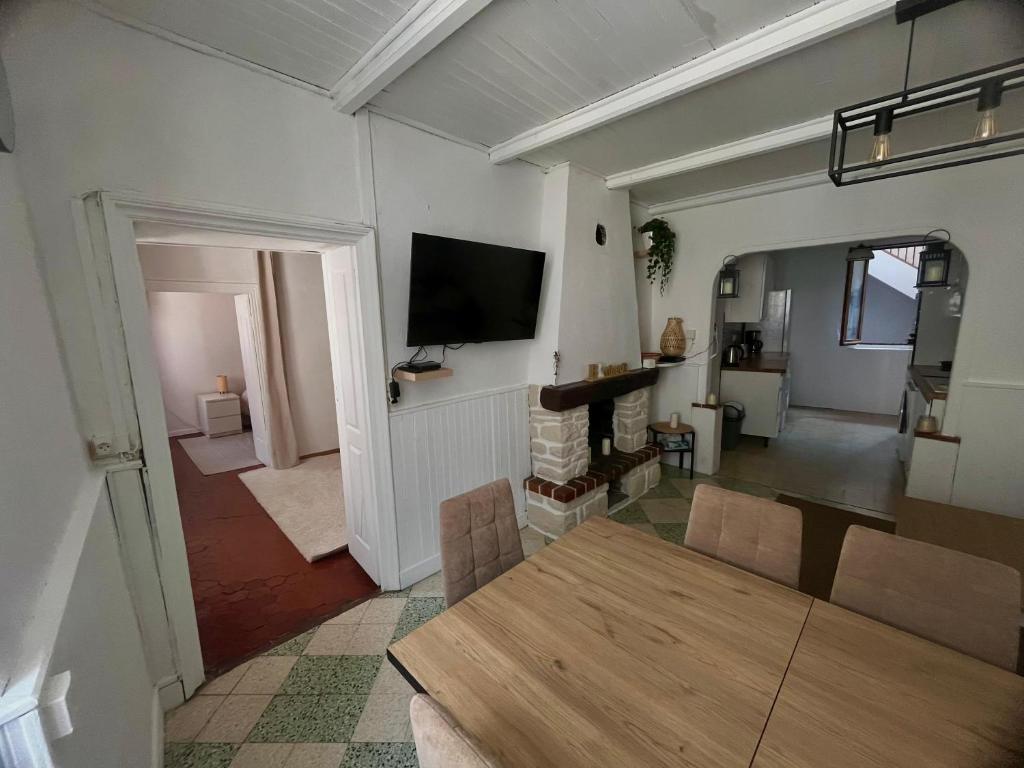 a living room with a table and a tv on the wall at Charmant in Saint-Martin-Vésubie