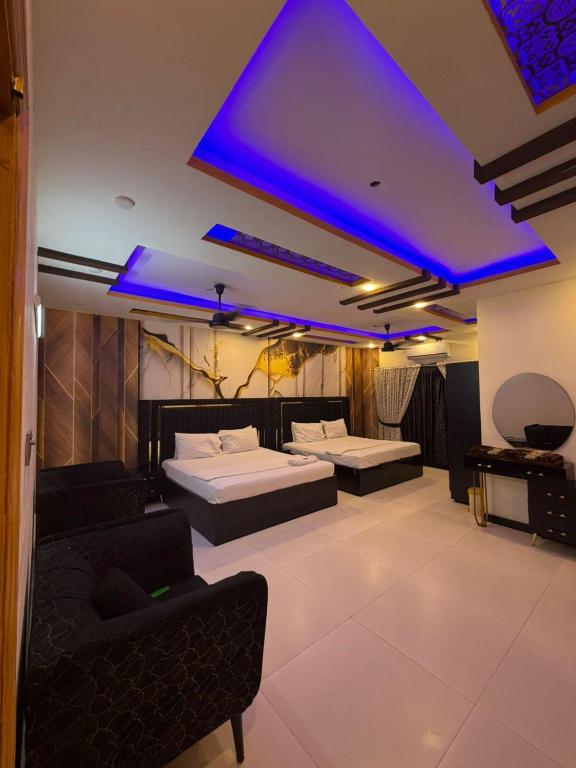 a room with two beds and a blue ceiling at Hotel Royal Sunset in Karachi