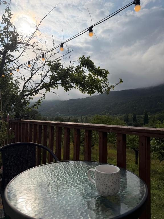 a coffee cup sitting on a glass table on a balcony at Skyla Glamping in Ambrolauri