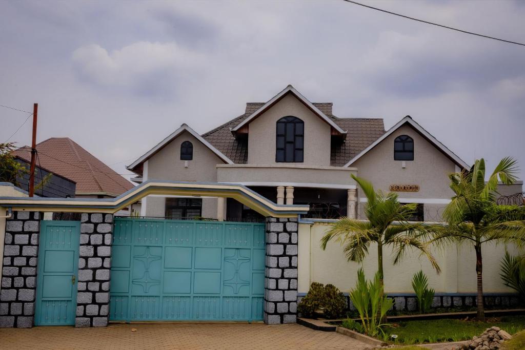 a house with blue garage doors and palm trees at Sabyinyo Crest in Cyuve