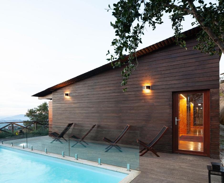 a house with a swimming pool next to a building at Casa do Avô in Cinfães