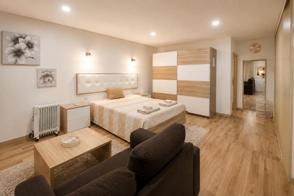 a hotel room with a bed and a couch at Imperial apartment 1, 2 e 3 in Braga