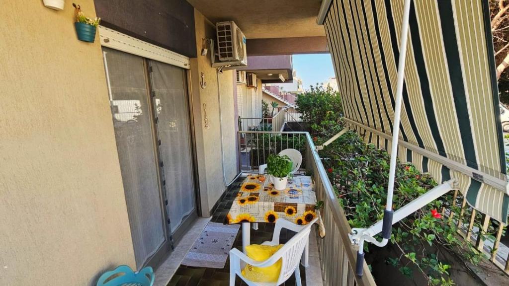 an apartment balcony with a table on a balcony gmaxwell gmaxwell gmaxwell gmaxwell gmaxwell at Casa Rose in Villaggio Azzurro