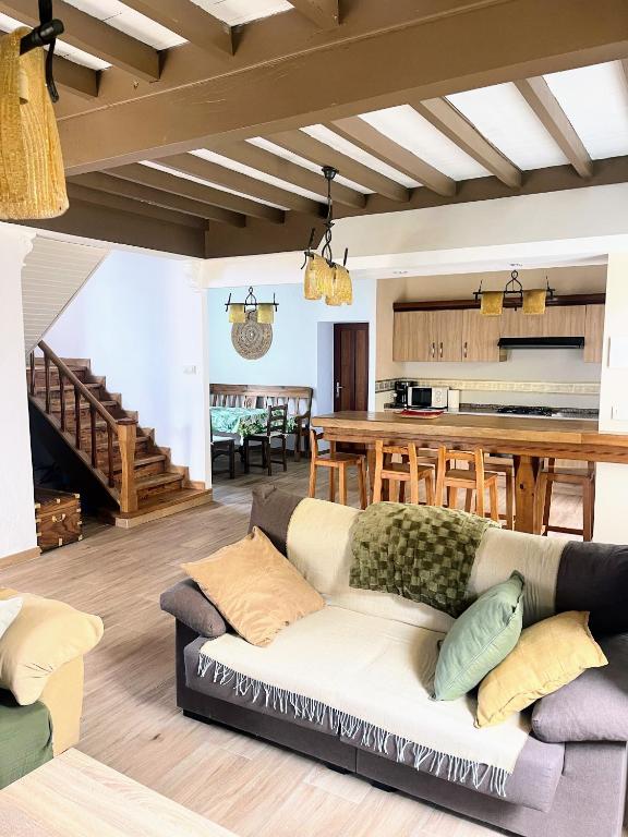a living room with a couch and a kitchen at Casa Rua in Lira