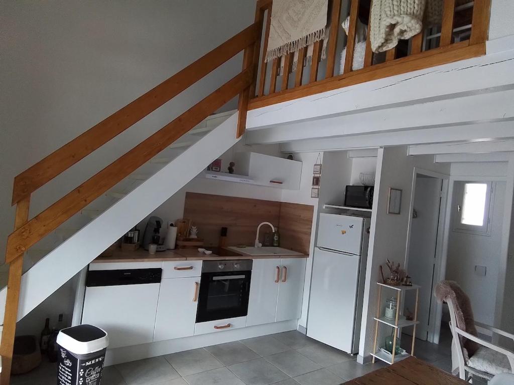 a kitchen with white cabinets and a staircase at style petit chalet de montagne in Prades