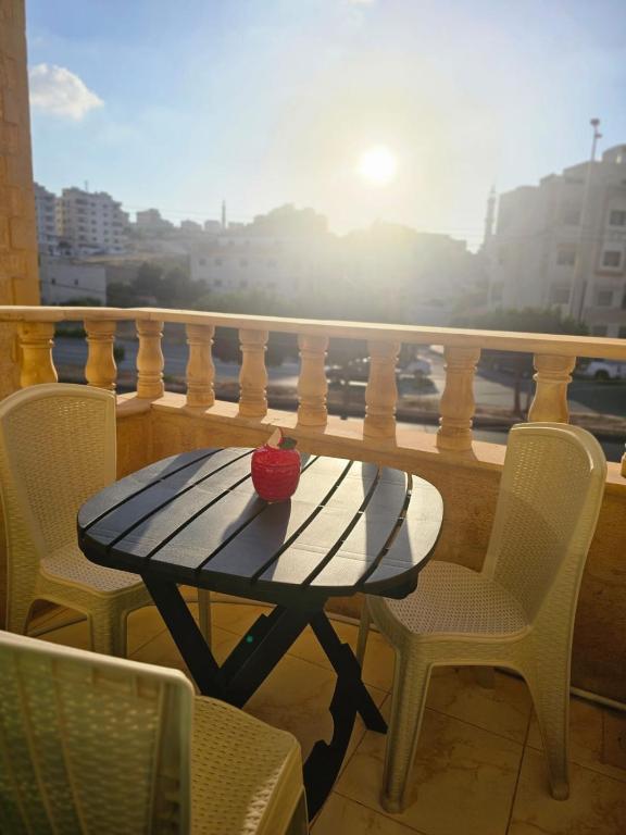 a table on a balcony with a view of a city at الجبيهه شفابدران شقة مفروشة in Amman