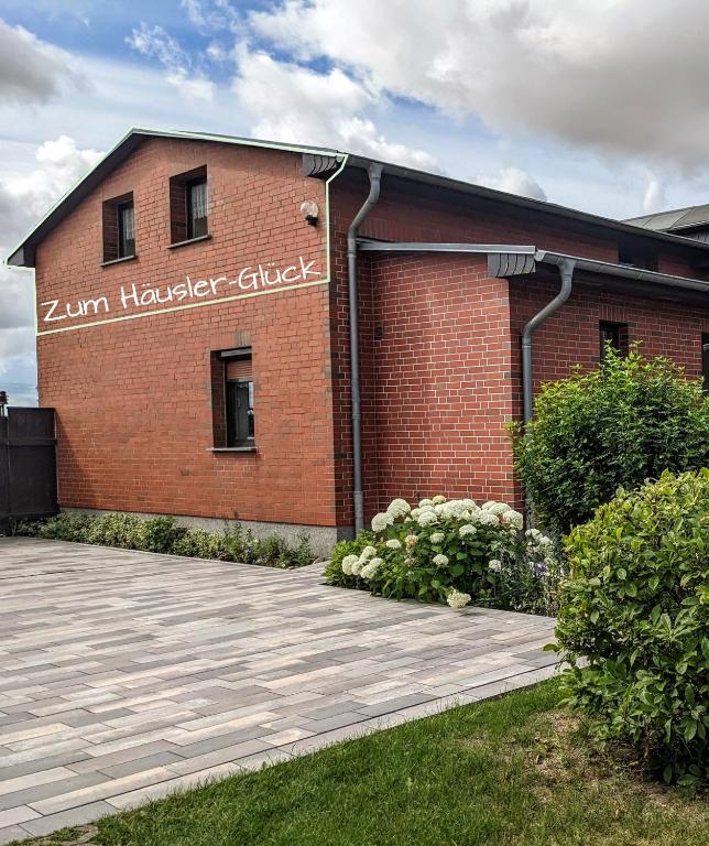 a brick building with a sign on the side of it at Zum Häusler-Glück in Biendorf