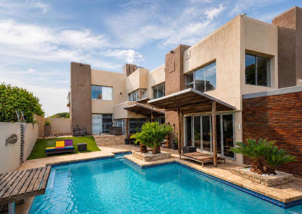 an exterior view of a house with a swimming pool at Nine on Uys street B & B in Jeffreys Bay