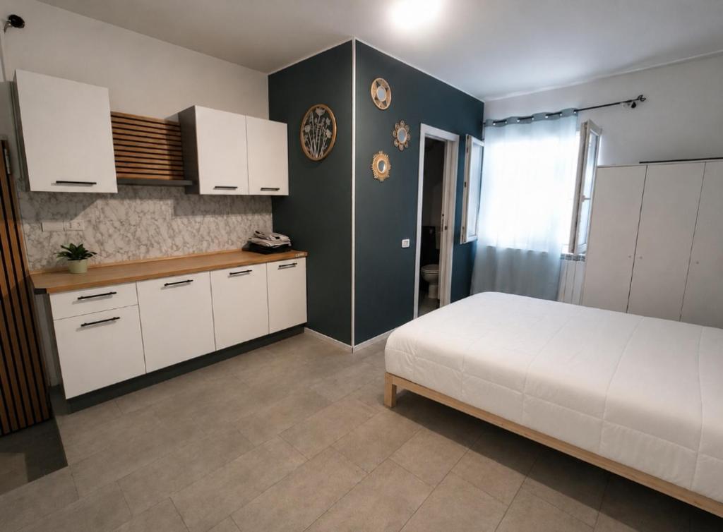 a bedroom with a white bed and white cabinets at Mercury Room in Limbiate