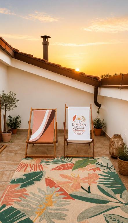 a patio with two chairs and a rug at La Dimora di Deborah Terrazza Panoramica, Centro & Stazione a 4 min, Relax e Comfort in Montecatini Terme