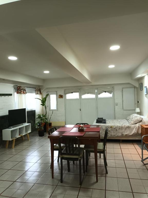 a living room with a table and a bed at Monoambiente Osvaldo in Neuquén