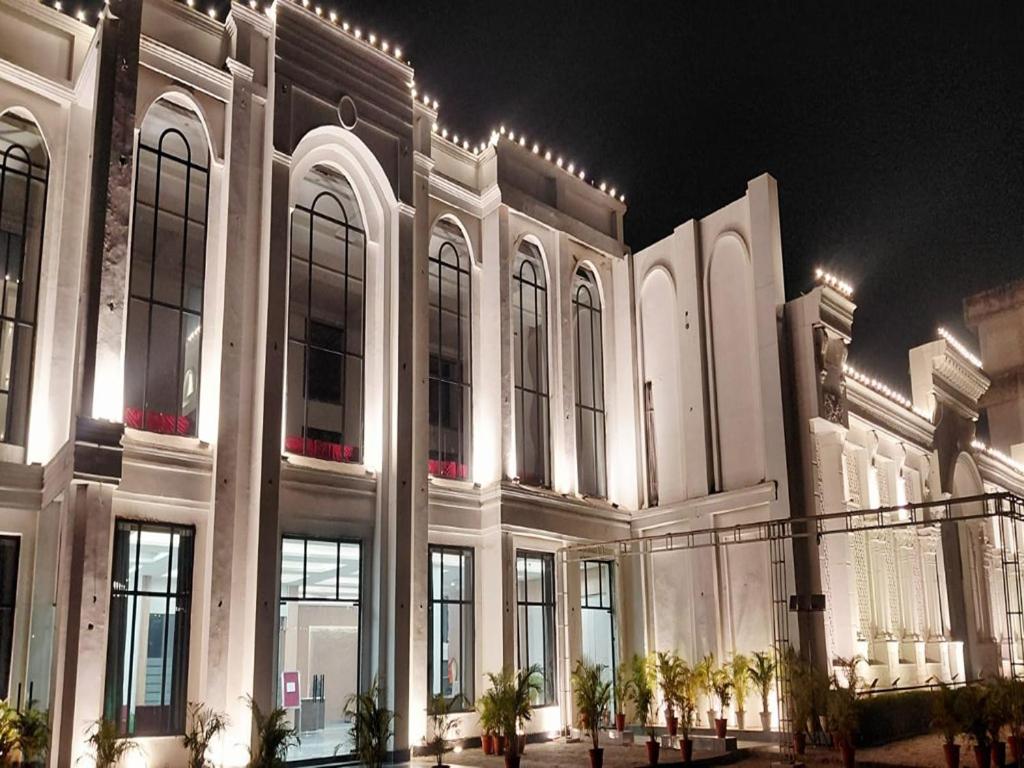 a large building with a lot of windows at night at Sparsh Hotel & Resort in Bareilly