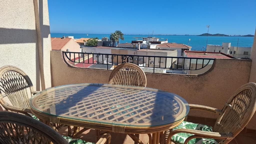 a table and chairs on a balcony with a view of the ocean at Ático Playa in Cartagena