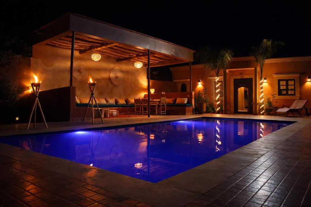a swimming pool at night with a house at Villa Dar Nata Marrakech in El Mers