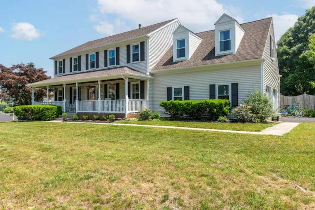 a white house with a large yard at Lrge 5 BR 9 Beds Near DC-Pool, Hot Tub, Gym, Game Rm, Fire Pit in Bowie