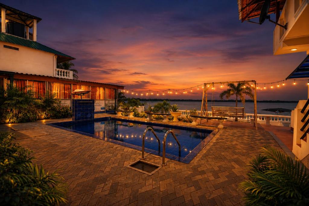 a swimming pool in front of a house at Dinuda Lagoon Hotel in Kalpitiya