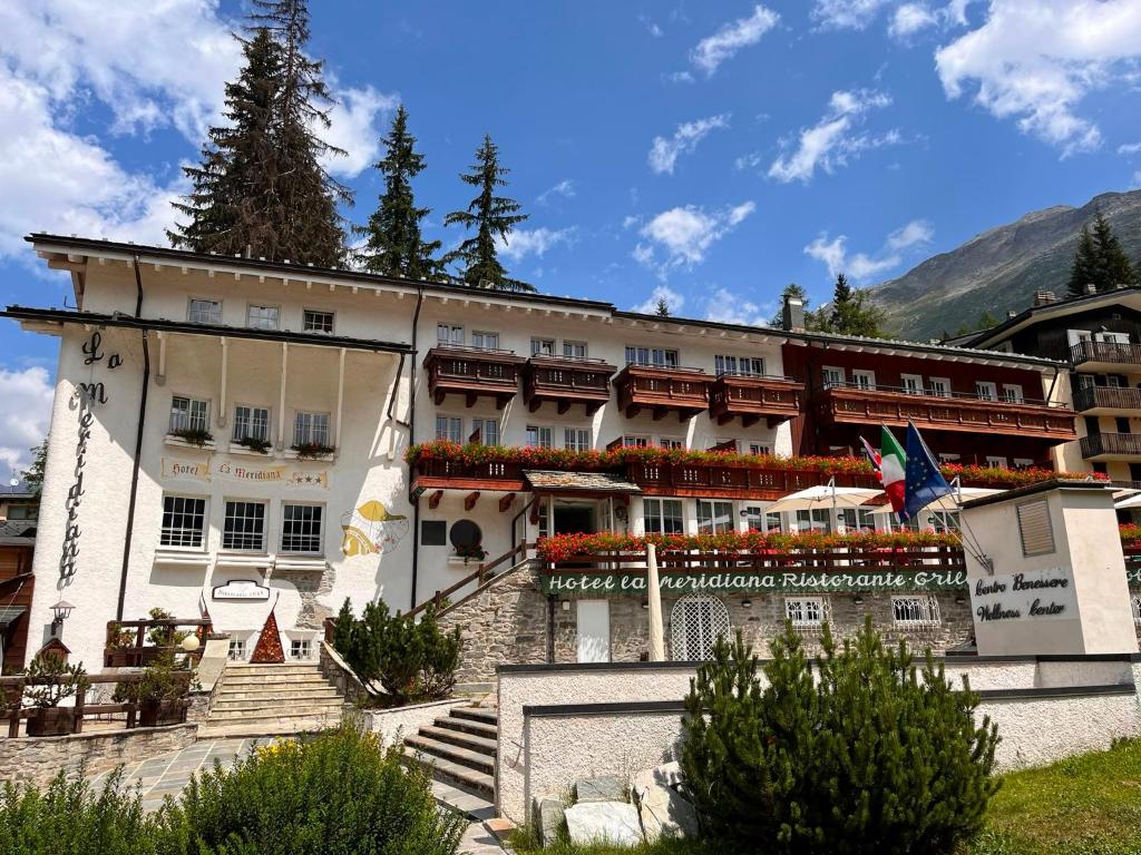 a large building with flowers in front of it at Hotel La Meridiana in Madesimo
