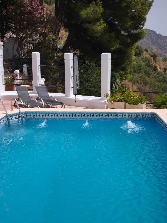 a swimming pool with two chairs and a swimming pool at Casa Limón - Alpujarras in Órgiva