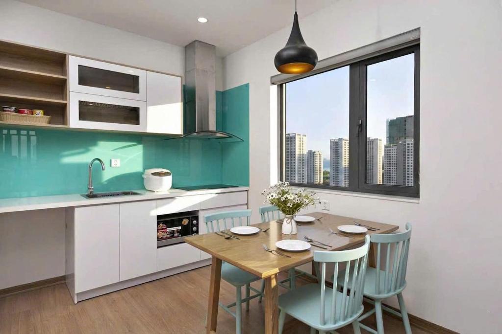 A compact apartment kitchen and dining area beside a city-facing window.