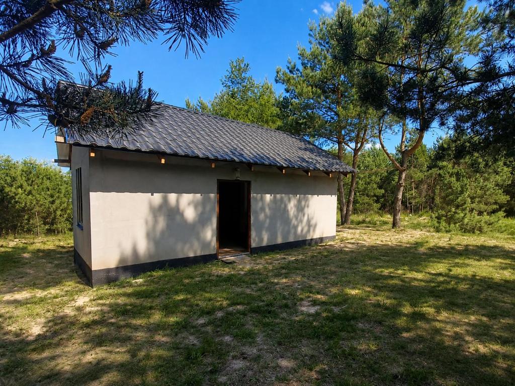 a small white building with a door in a field at DOMEK na górce u Celiny in Dargobądz
