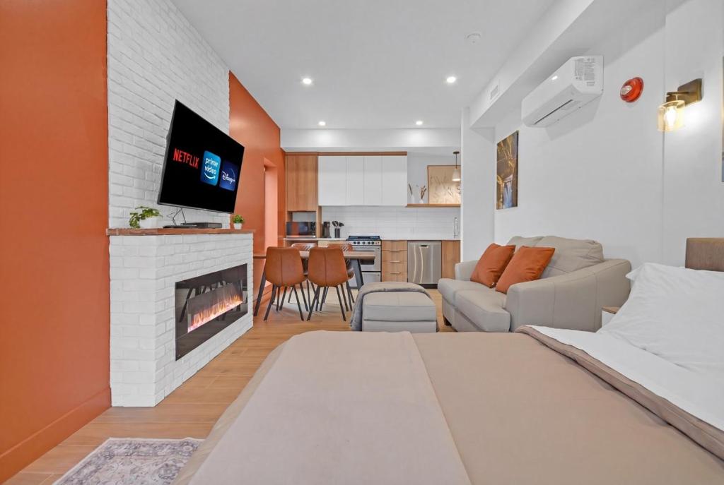 a bedroom with a bed and a living room with a fireplace at Lofts Orizon in Rimouski