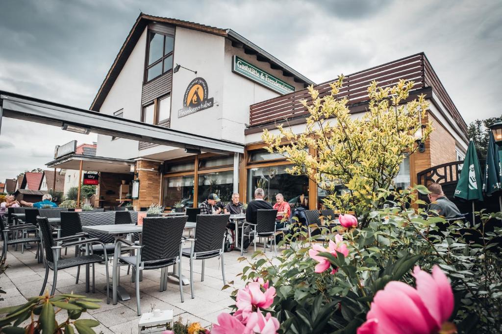 a restaurant patio with tables and chairs and flowers at Frankenstube in Eichelsdorf