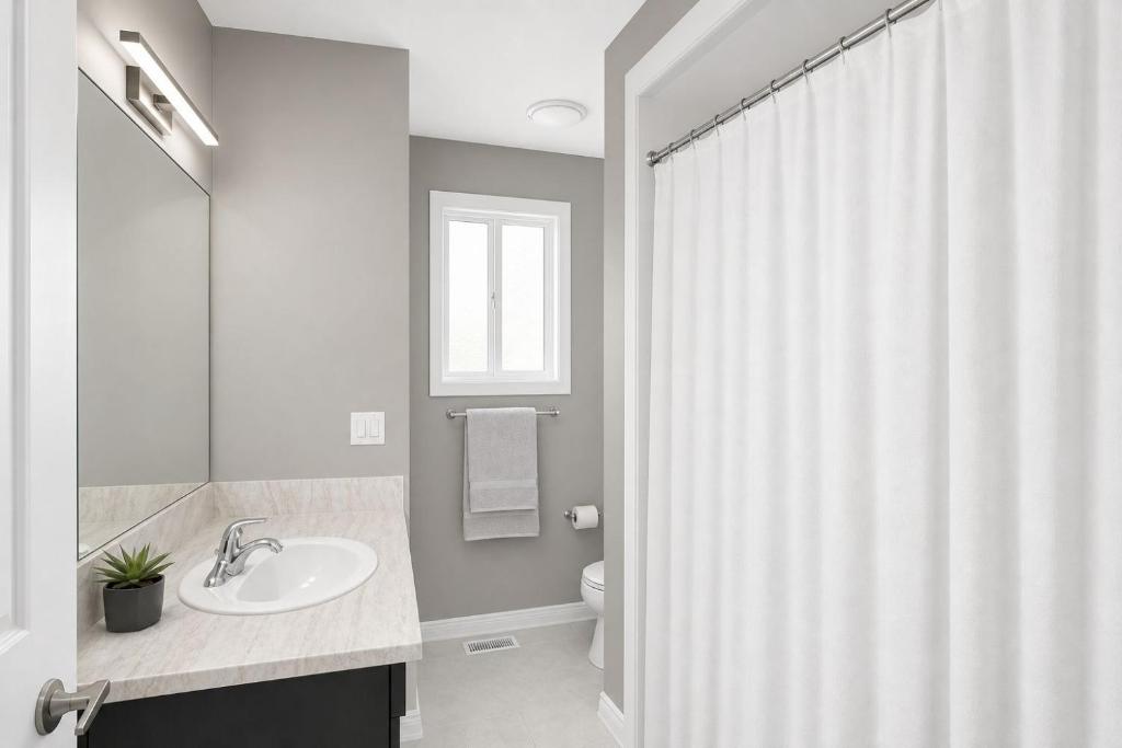 a bathroom with a sink and a shower curtain at PEAK AND PINE GETAWAY in Eden