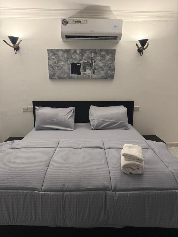 a bedroom with a bed with a white towel on it at Bedroom Jimi in Al Ain