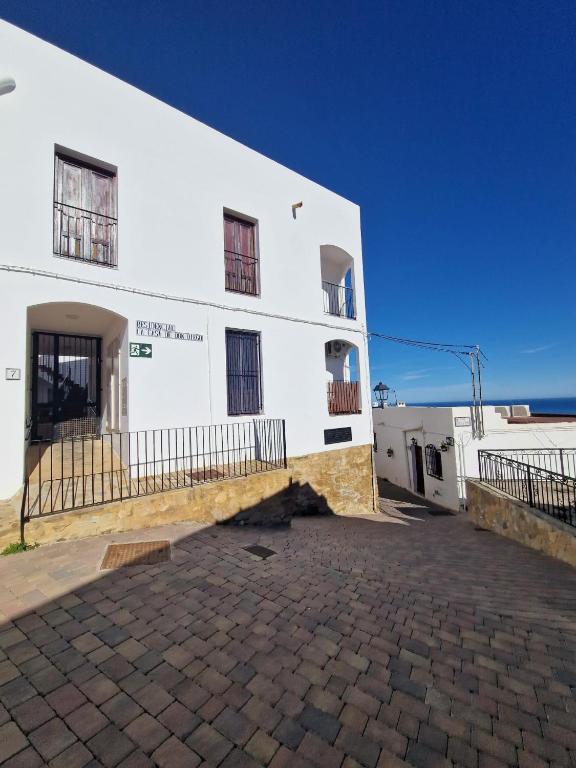 a white building with a brick driveway in front of it at Casa María in Mojácar