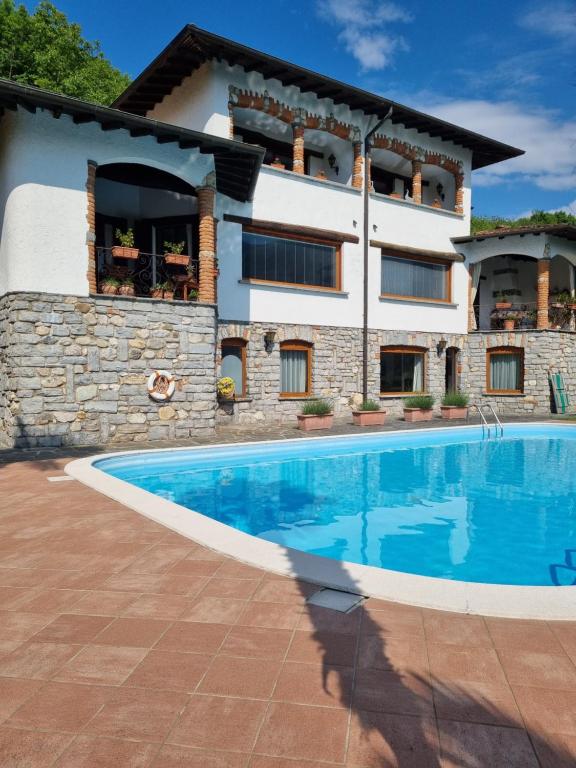 a house with a swimming pool in front of a building at Glicine in Carlazzo