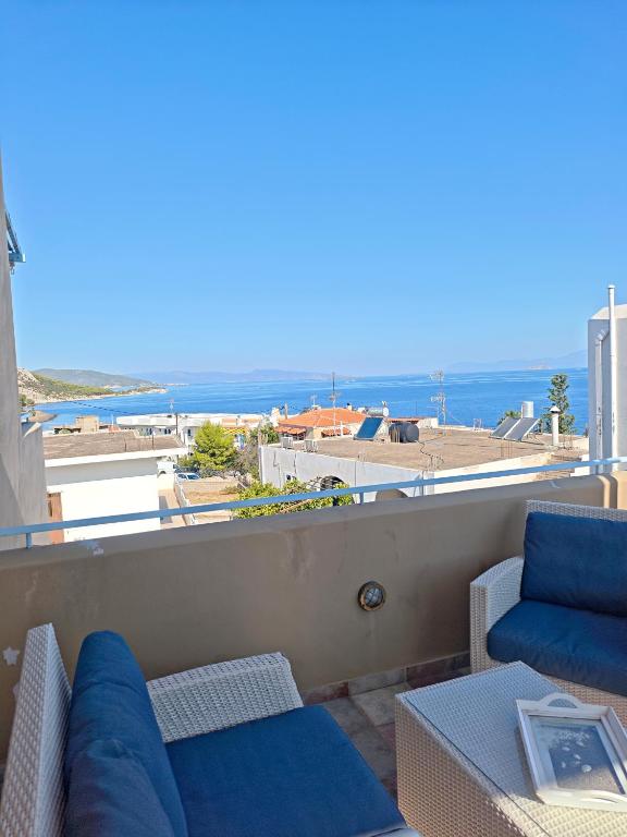 a balcony with a couch and a view of the ocean at KLIMA apartment in Perdika