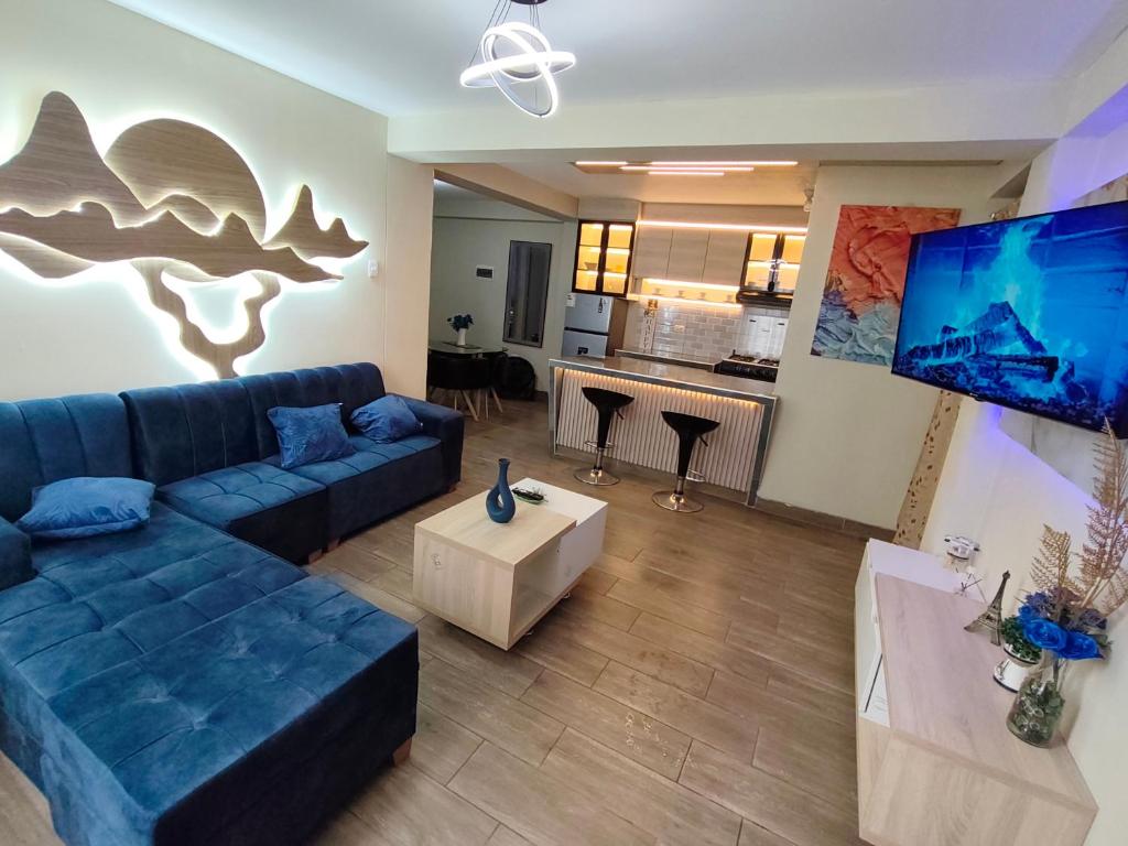 a living room with a blue couch and a kitchen at DEPPIu in Piura