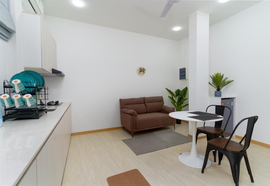 a kitchen and living room with a couch and a table at Nest and nook in Ukulhas