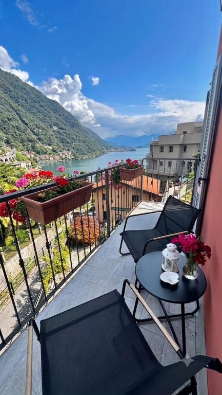 a balcony with a table and chairs and a view of the water at Crotto bedroom in Argegno