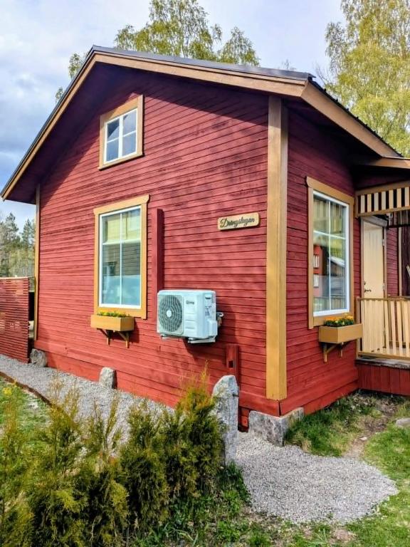 a red house with a window and a heater on it at Kolsta Gård 