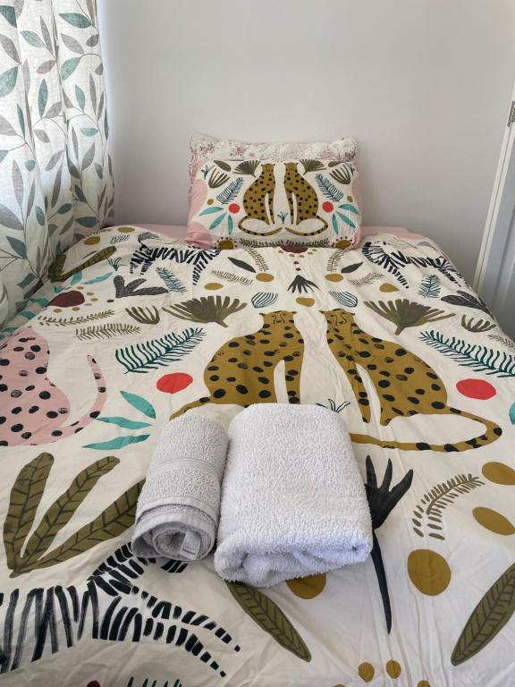 a bed with a blanket and towels on it at Private studio with a private bathroom and kitchenette in Edmonton