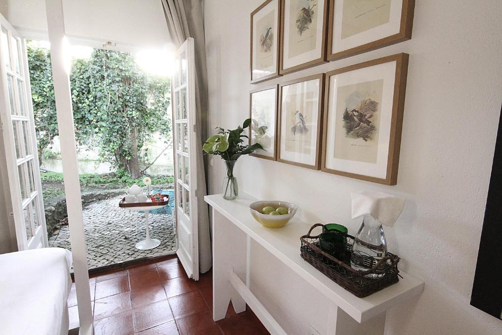 a room with a white table and some pictures on the wall at Senhora do Cabo Meco Homy Holidays in Sesimbra