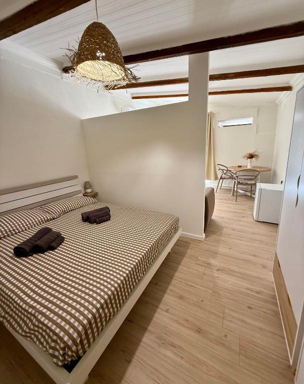 a bedroom with a bed and a dining room at La Maison Fleurie in San Nicola Arcella