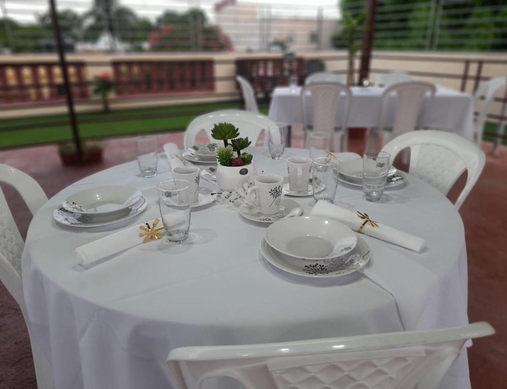 a white table with plates and glasses on it at SDQ Apartamento in Los Tres Ojos de Agua