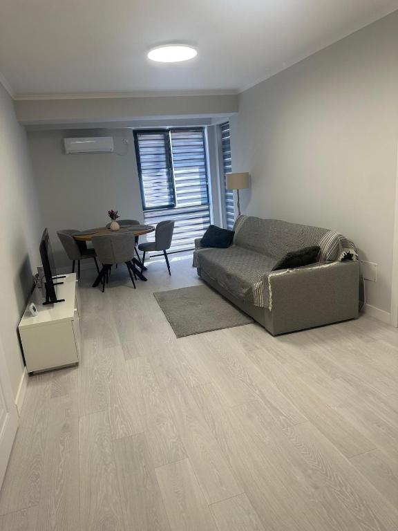 a living room with a bed and a dining table at Modern Apartment Constanța in Constanţa