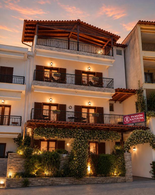 a large white building with plants on the facade at Pansion Katerina in Ouranoupoli