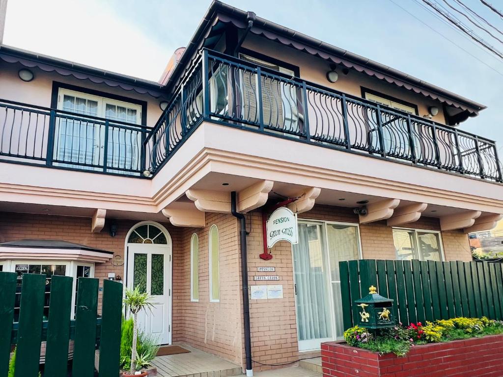 a house with a balcony on top of it at Pension Green Grass in Kamakura