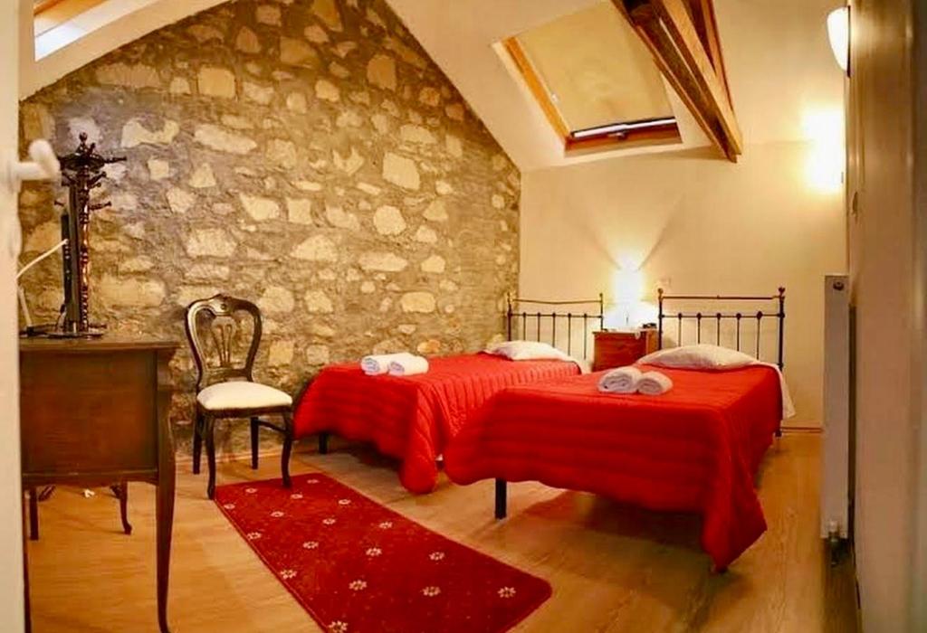 a bedroom with two beds and a stone wall at Archontiko Olympias Boutique Hotel in Mytilene