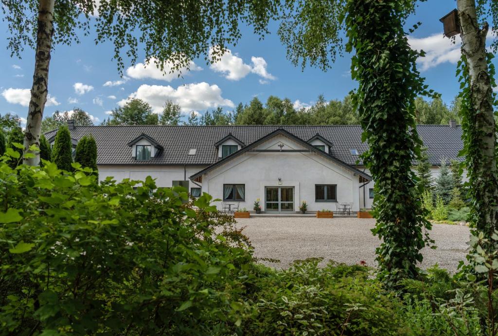 a large white house with black roof at Gościniec Sarnówka 