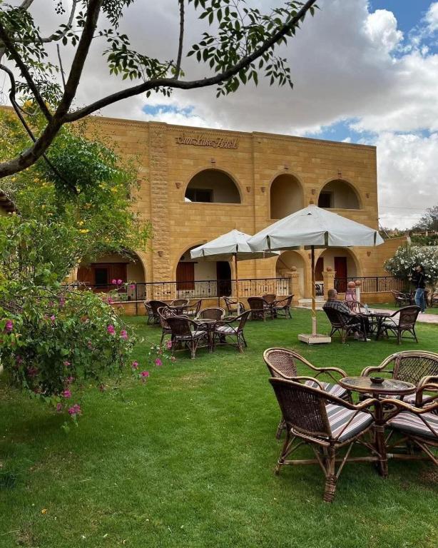 a group of tables and chairs in front of a building at Sun Lake Hotel in Tunis